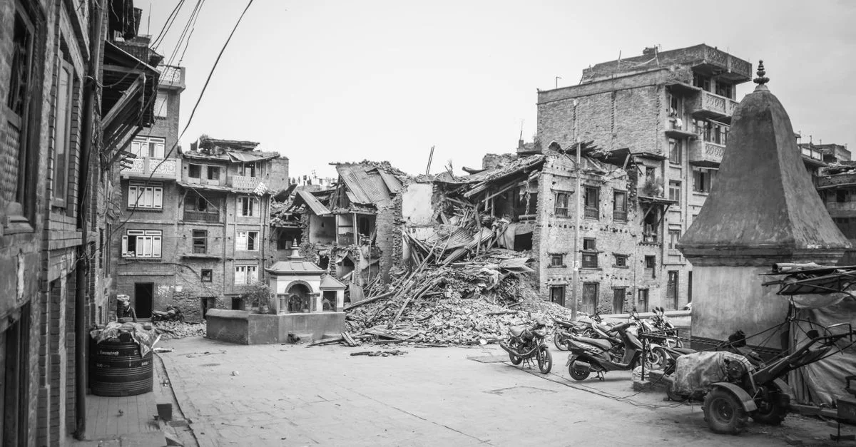 Une vue monochrome des conséquences d'un tremblement de terre à Bhaktapur, montrant la destruction urbaine et des bâtiments endommagés.